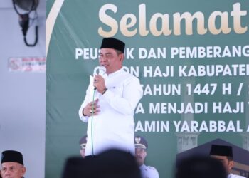 Bupati Aceh Besar, Muharram Idris (tengah), memberikan sambutan pada prosesi peusijuk dan pelepasan jamaah calon haji Kabupaten Aceh Besar tahun 1447 H/2026 M di Masjid Bustanul Jannah, Gampong Ajuen, Kecamatan Peukan Bada, Selasa (28/04/2026). FOTO/MC ACEH BESAR.
