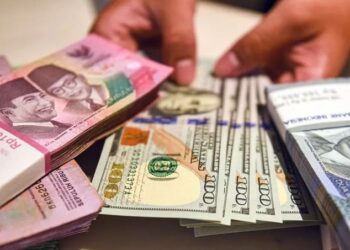 Ilustrasi - Petugas menunjukan uang pecahan dolar AS dan rupiah di Bank BSI, Jakarta. ANTARA FOTO/Muhammad Adimaja/Spt/am/pri.