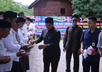 Bupati Aceh Besar H Muharram Idris bersama Ulama Karismatik Aceh Abu Athailah melakukan prosesi peusijuek kepada ratusan guru Beut Kitab bak Sikula, di halaman Gedung Dekranasda Aceh Besar, Kamis (18/6/2026). FOTO/ MC ACEH BESAR