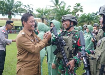 Wakil Bupai Aceh Besar Drs Syukri A Jalil, bersama unsur Forkopimda menyalami prajurit saat menghadiri Pemberangkatan Satgas RI-PNG Statis YOnif 117/KY Rem 012/TU Kodam IM, di Lapangan Mayonif 117/KY, Kota Jantho, Senin (29/06/2026). FOTO/MC ACEH BESAR