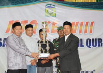 Camat Baitussalam Ridwan SE Ak (kiri) saat menyerahkan piala pemenang MTQ Kecamatan, Minggu (28/6/2026) malam. FOTO/MC ACEH BESAR