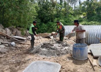Personel Babinsa Posramil Bukit Tusam, jajaran Kodim 0108/Aceh Tenggara, turun langsung mendampingi warga dalam pembangunan Jembatan Aramco di Desa Sebudi Jaya, Kecamatan Bukit Tusam, Kabupaten Aceh Tenggara, Senin (20/7/2026).