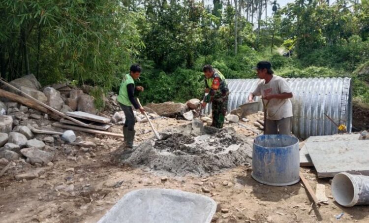 Personel Babinsa Posramil Bukit Tusam jajaran Kodim 0108Aceh Tenggara turun langsung mendampingi warga dalam pembangunan Jembatan Aramco di Desa Sebudi Jaya Kecamatan Bukit Tusam Kabupaten Aceh Tenggara Senin 2072026