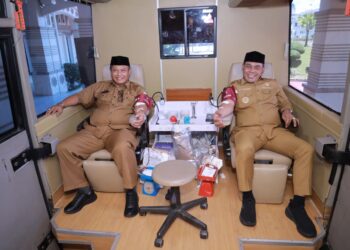 Bupati Aceh Besar H Muharram Idris, Sekda Bahrul Jamil SSos MSi mendonorkan darahnya pada kegiatan donor darah yang digelar di Kantor Bupati Aceh Besar, Senin (27/7/2026). FOTO/ PROKOPIM PEMKAB ACEH BESAR
