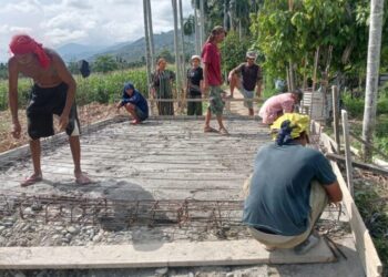 Personel Babinsa Posramil Lawe Bulan dari jajaran Kodim 0108/Aceh Tenggara bahu-membahu bersama warga melaksanakan kegiatan pengecoran pondasi Jembatan Aramco di Desa Lawe Kinge, Kecamatan Lawe Bulan, Kabupaten Aceh Tenggara, pada Minggu (26/7/2026).