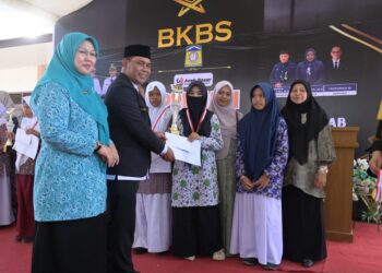 Bupati Aceh Besar, H Muharram Idris menyerahkan hadiah kepada siswa Lomba dan Pembagian Hadiah Beut Kitab Bak Sikula di SMPN 1 Kecamatan Darul Imarah, Aceh Besar, Kamis (30/07/2026). FOTO/MC ACEH BESAR