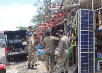 Petugas Satpol PP dan WH Aceh Besar melakukan penertiban terhadap kanopi toko yang gunakan fasilitas umum, di kawasan Gampong Tanjong Selamat, Kecamatan Darussalam, Kabupaten Aceh Besar, Kamis (30/7/2026). FOTO/ MC ACEH BESAR