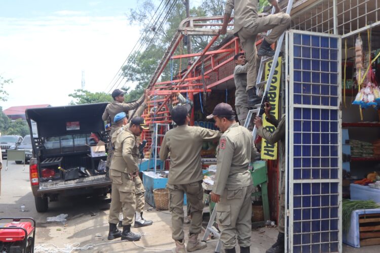 Petugas Satpol PP dan WH Aceh Besar melakukan penertiban terhadap kanopi toko yang gunakan fasilitas umum di kawasan Gampong Tanjong Selamat Kecamatan Darussalam Kabupaten Aceh Besar Kamis 3072026 FOTO MC ACEH BESAR