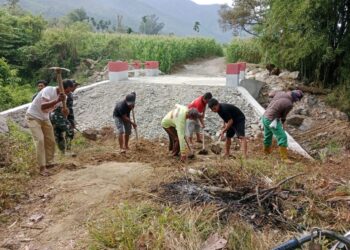 Babinsa Posramil Deleng Pokhkisen jajaran Kodim 0108/Aceh Tenggara, Serda Arpit Journalis, bersama warga Desa Bunga Melut bahu-membahu melaksanakan gotong royong menimbun sisi kiri dan kanan Jembatan Beton, Sabtu (8/8/2026).