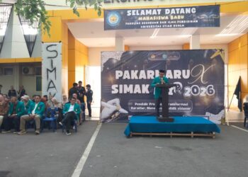 Wakil Dekan Bidang Kemahasiswaan, Alumni dan Kemitraan FKIP USK, Prof. Dr. Asnawi, S.Pd., M.Ed., saat membacakan laporan kepanitiaan kegiatan Pembinaan Akademik dan Karakter Mahasiswa Baru (PAKARMARU) serta Silaturahmi Mahasiswa Aneuk Keguruan (SIMAK) FKIP USK Tahun 2026. di Stadion Mini USK pada Sabtu (15/8/2026).