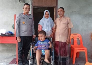 Kapolres Aceh Selatan, AKBP T. Ricki Fadlianshah, turun langsung menyerahkan bantuan kemanusiaan berupa kursi roda kepada Ikram (7), seorang anak penyandang disabilitas di Gampong Lhok Pawoh, Kecamatan Sawang, Kabupaten Aceh Selatan, Selasa (18/8/2026).