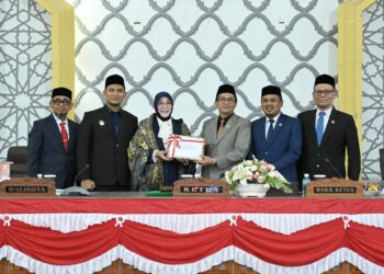Wali Kota Banda Aceh, Illiza Sa’aduddin Djamal, didampingi Wakil Wali Kota, Afdhal Khalilullah Mukhlis dan Sekda Kota Jalaluddin menyerahkan dokumen RKUA PPAS Perubahan APBK Banda Aceh 2026 kepada Pimpinan DPRK Banda Aceh, yaitu Ketua DPRK Banda Aceh, Irwansyah ST, didampingi dua wakil ketua, Daniel Abdul Wahab dan Musriadi Aswad, dalam sidang paripurna yang berlangsung di Gedung DPRK setempat, Senin (24/8/2026) pagi. FOTO/HUMAS DPRK BANDA ACEH