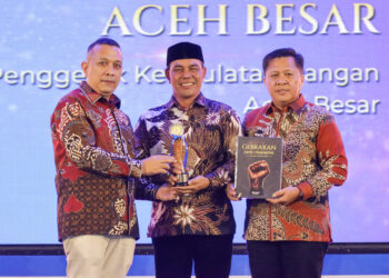 Bupati Aceh Besar H Muharram Idris (Syech Muharram), terima penghargaan Serambi Awards 2026, kategori Penggerak Kedaulatan Pangan Kabupaten Aceh Besar, dalam ajang Gebrakan Pemimpin yang digelar di AAC Dayan Dawood, Darussalam, Kota Banda Aceh, Sabtu (29/8/2026) malam. FOTO/ PROKOPIM PEMKAB ACEH BESAR