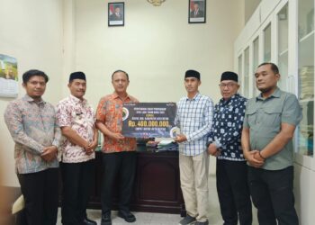 Wakil Bupati Aceh Besar Drs H Syukri menyaksikan proses penyerahan zakat perusahaan PT Bank Aceh Syariah kepada pengurus Baitul Mal Kabupaten Aceh Besar sebesar Rp 400 juta di ruang rapat Kantor Bupati Aceh Besar Kamis siang 392026 FOTO PROKOPIM PEMKAB ACEH BESAR