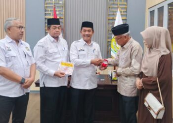 Wakil Bupati Aceh Besar Drs Syukri menyerahkan cenderamata dari Pemerintah Aceh kepada ahli waris keluarga pahlawan T Nyak Makam di ruang kerja Wabup Aceh Besar, Rabu (16/9/2026). FOTO/ PROKOPIM PEMKAB ACEH BESAR