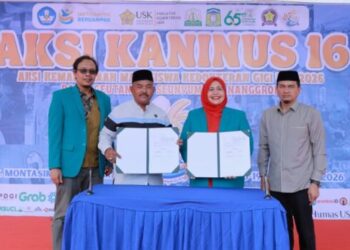 Asisten II Sekda Aceh Besar, M Ali SSos MSi, dan Dekan FKG USK Dr drg Zulfan Alibasyah Sp Perio, memperlihatkan perjanjian kerjasama, pada pembukaan Aksi Kaninus 16 di Lapangan Lampoh Kawat, Kecamatan Montasik, Aceh Besar, Jumat (18/9/2026). FOTO/ MC ACEH BESAR