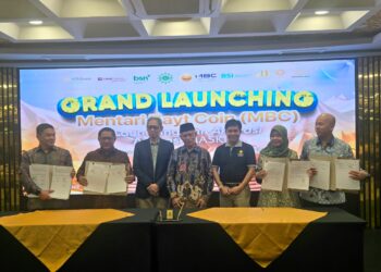 Direktur Finance & Strategy PT Bank Syariah Indonesia (Persero) Tbk (BSI) Ade Cahyo Nugroho (paling kanan) bersama Ketua Umum Pimpinan Pusat (PP) Muhammadiyah Prof. Dr. K.H. Haedar Nashir (tengah), Direktur Utama PT Mentari Bayt Coin (MBC) Prof. Dr. Jebul Suroso (ketiga dari kanan), dan Ketua Majelis Diktilitbang PP Muhammadiyah sekaligus Komisaris Utama PT MBC Prof. Dr. Bambang Setiaji, M.Si (ketiga dari kiri) didampingi jajaran pimpinan mitra strategis lainnya, menunjukkan dokumen Nota Kesepahaman (MoU) pada acara Grand Launching Mentari Bayt Coin (MBC) di SM Tower Malioboro, Yogyakarta, Sabtu (19/9/2026). Kemitraan strategis antara BSI dan entitas bisnis Muhammadiyah ini difokuskan pada pengembangan inovasi investasi emas dan perluasan inklusi keuangan syariah melalui produk co-branding BSI Gold. (Foto: Dok. Istimewa/BSI)