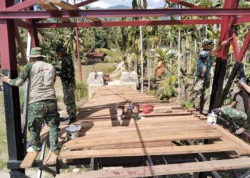 Babinsa jajaran Kodim 0108Agara bersama masyarakat menggelar aksi gotong royong mengecat tiang pylon jembatan pada Selasa 2292026 FOTO HUMAS