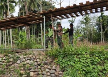 Prajurit Kodim 0108/Aceh Tenggara dan warga bergotong royong memasang tiang penahan lantai jembatan gantung di Desa Lawe Ger Ger, Kecamatan Ketambe, Kabupaten Aceh Tenggara, Kamis (24/9/2026). FOTO: HUMAS.