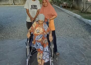 Sariana Hasibuan, lansia 76 tahun, menggunakan kursi roda bantuan Pemerintah Aceh melalui Dinas Sosial Aceh, didampingi anggota keluarga di Banda Aceh, Kamis (24/9/2026). Foto: (Dinsos Aceh).