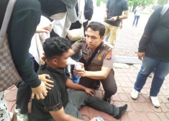 Personel Biddokkes Polda Aceh memberikan pertolongan awal kepada seorang peserta aksi yang terjatuh akibat berdesakan dan membutuhkan bantuan pernapasan saat unjuk rasa di Kantor Gubernur Aceh Selasa 20102026 FOTO Polda Aceh
