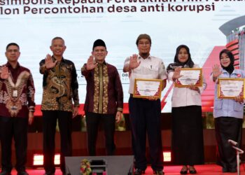 Wakil Gubernur Aceh Fadhlullah Dek Fadh bersama Wakil Ketua Komisi Pemberantasan Korupsi KPK Republik Indonesia Ibnu Basuki Widodo menyerahkan penganugerahan Percontohan Desa Antikorupsi Provinsi Aceh Tahun 2026 kepada 15 desa dari berbagai kabupaten dan kota di Aceh Rabu 21102026