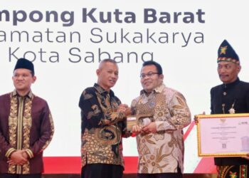 Keuchik Gampong Kuta Barat Eddy Syahputra menerima penghargaan Desa Percontohan Antikorupsi Aceh 2025 didampingi Wali Kota Sabang Zulkifli H Adam di Gedung Anjong Mon Mata Banda Aceh Rabu 2110 FOTO Humas