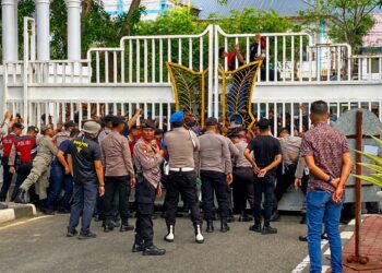 Personel Polda Aceh saat mengamankan aksi penyampaian aspirasi yang dilakukan Front Mahasiswa Aceh Resisten di halaman Kantor Gubernur Aceh, Rabu 21/10/ 2026.